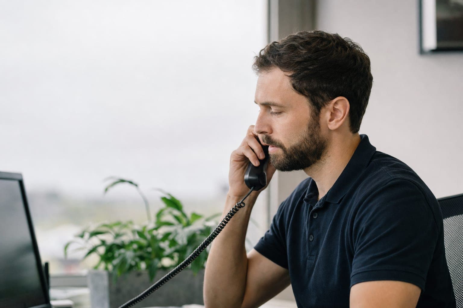 Mitarbeiterin im Telefonat am Schreibtisch, bereit für Ihr Erstgespräch